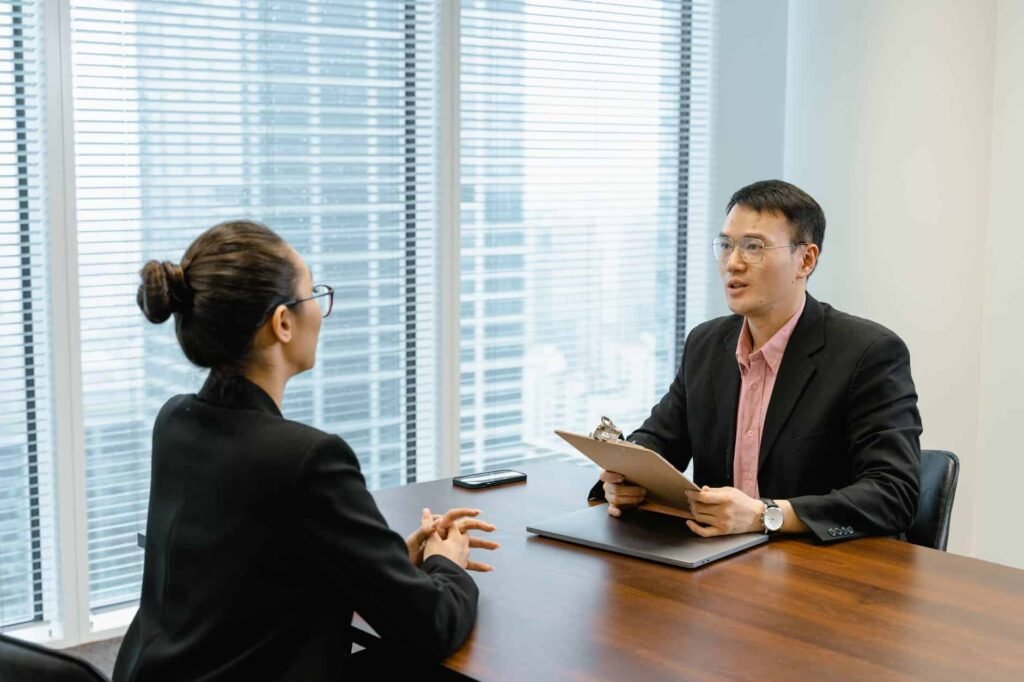 How to avoid job interview mistakes? Let's check out Top 10. man in glasses holding a folder while talking to a woman in suit
