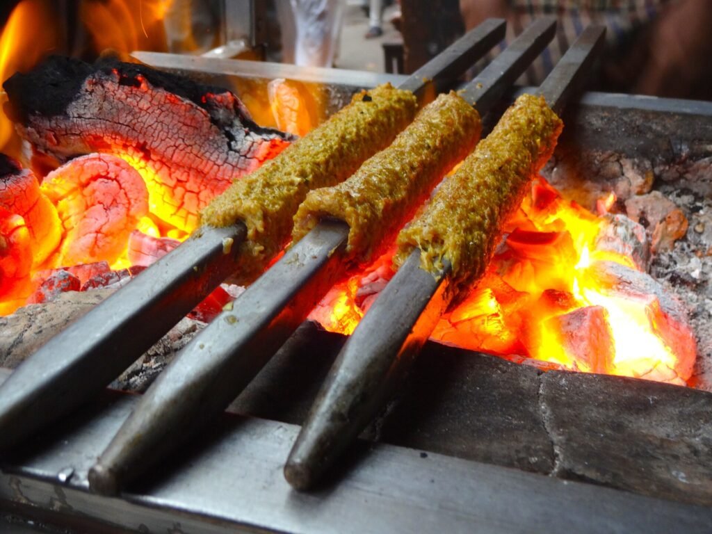 Aligarh Food Guide: Famous Dishes and Food Streets to Try Seekh kebabs cooking over a charcoal grill