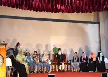 AMU Women's College students take part in a Sir Syed quiz on stage, with a student dressed as Sir Syed Ahmad Khan